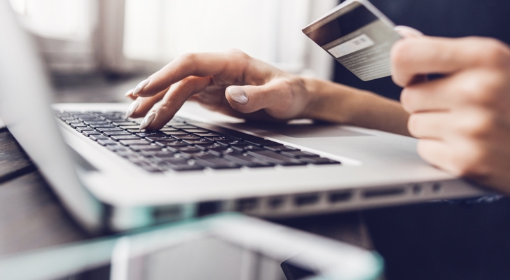 PErson sidder ved bærbar og betaler online med dankort